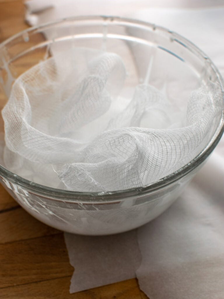 A piece of cheesecloth sitting in a bowl of liquid starch mixed with water.