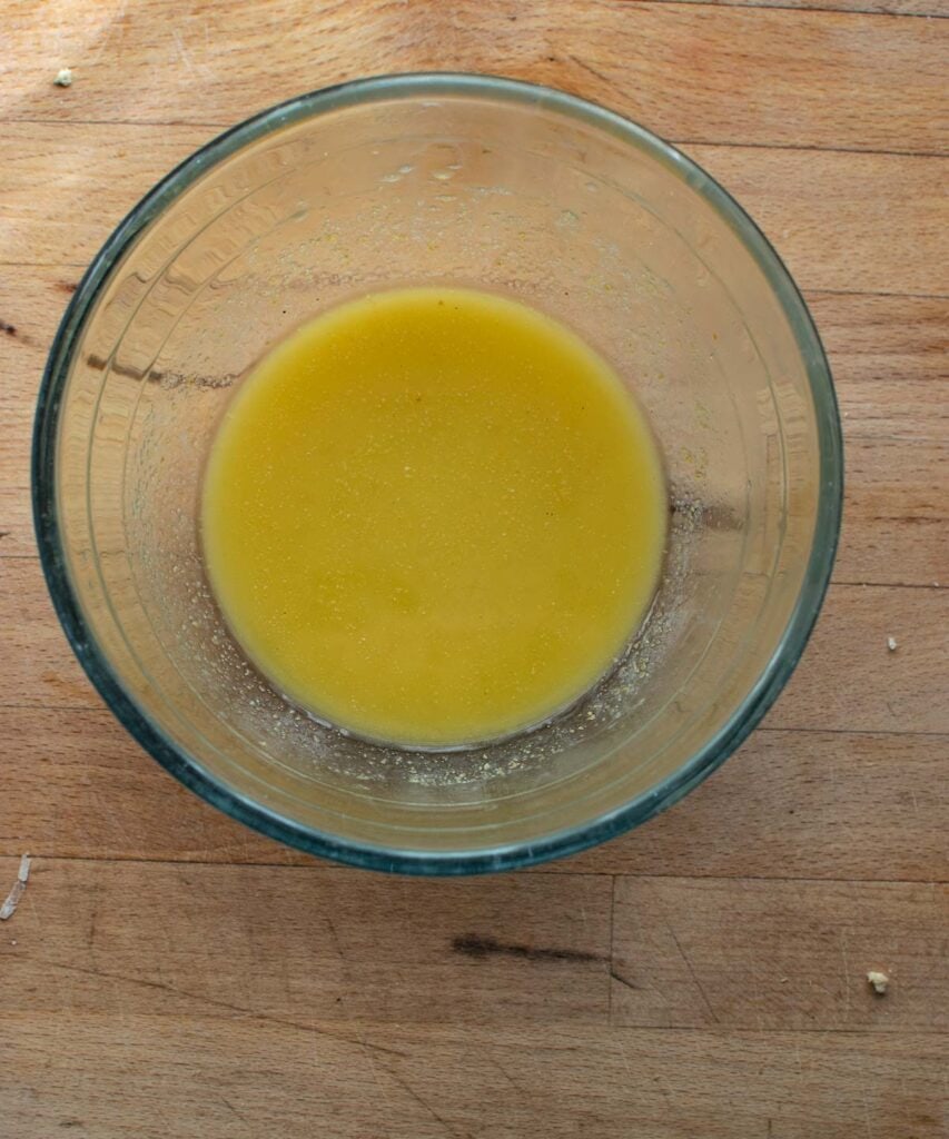 Melted butter and seasonings in a mixing bowl to dredge chicken in before breading.