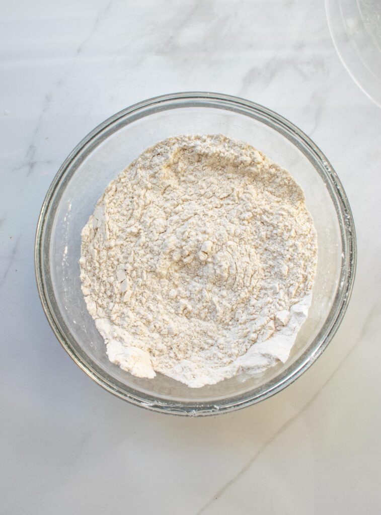 All purpose flour, baking soda, baking powder, cinnamon, nutmeg and salt whisked together to make an applesauce cranberry loaf.