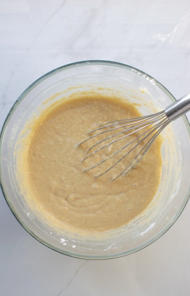 Applesauce mixture combined with flour mixture to make batter for an applesauce cranberry quick bread.