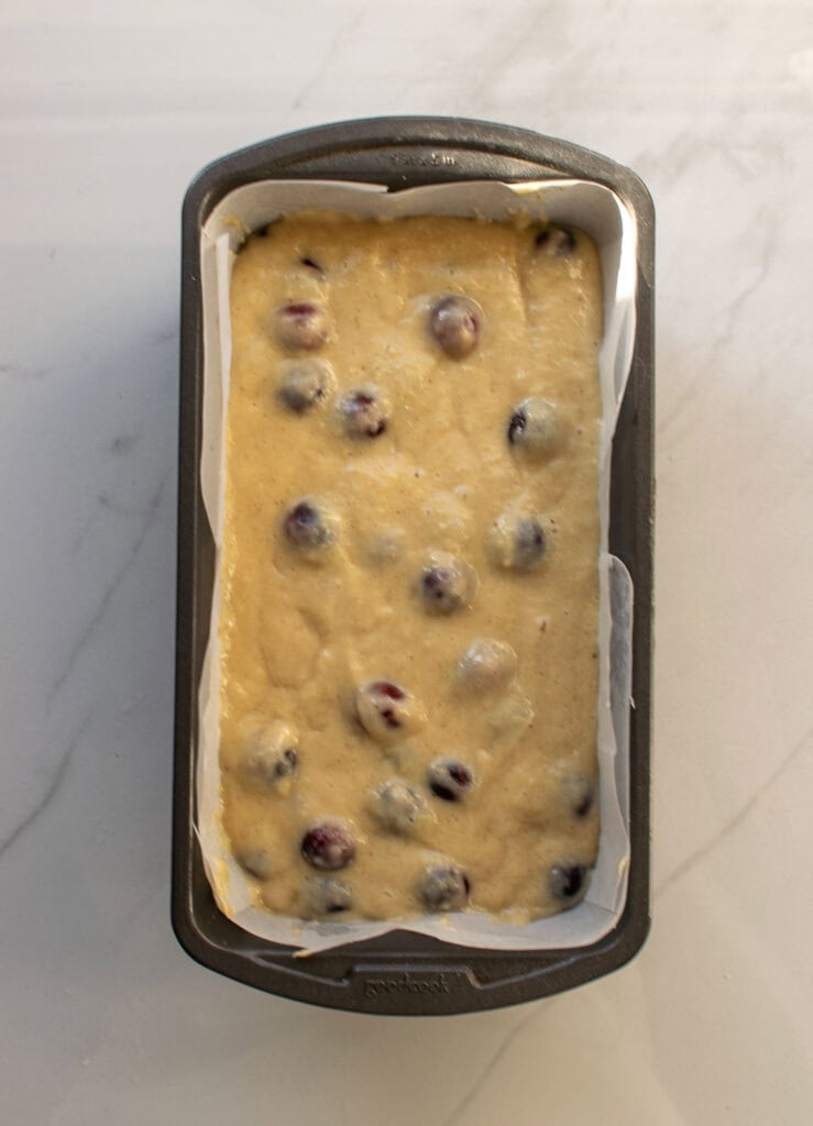 Batter for cinnamon apple quick bread with fresh cranberries in a loaf pan before baking.