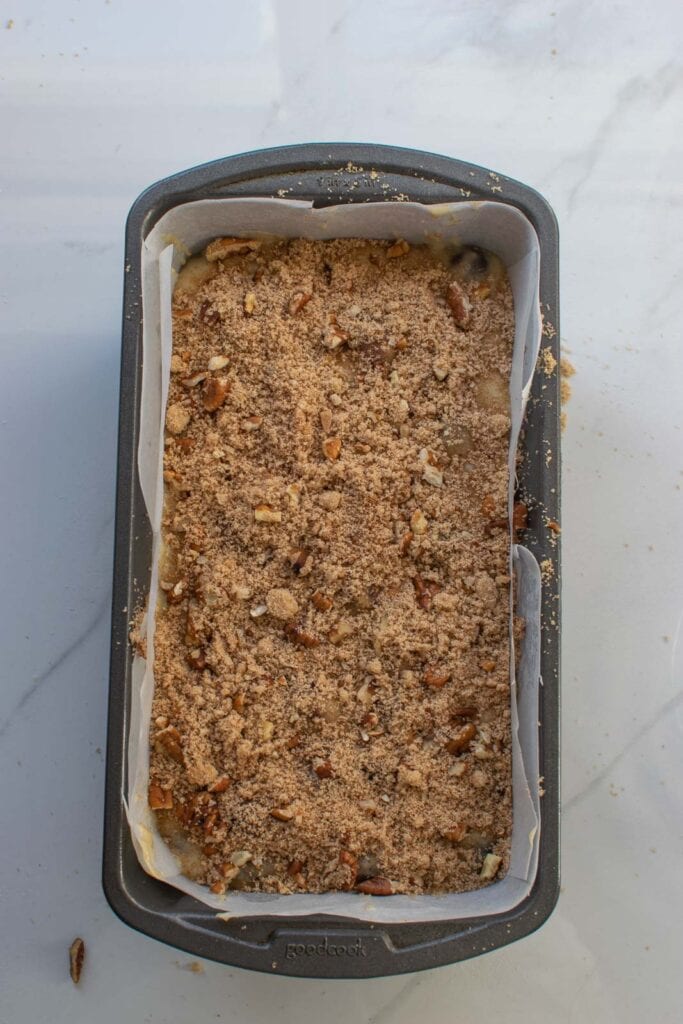 Applesauce bread with cranberries topped with a pecan brown sugar crumble before baking.