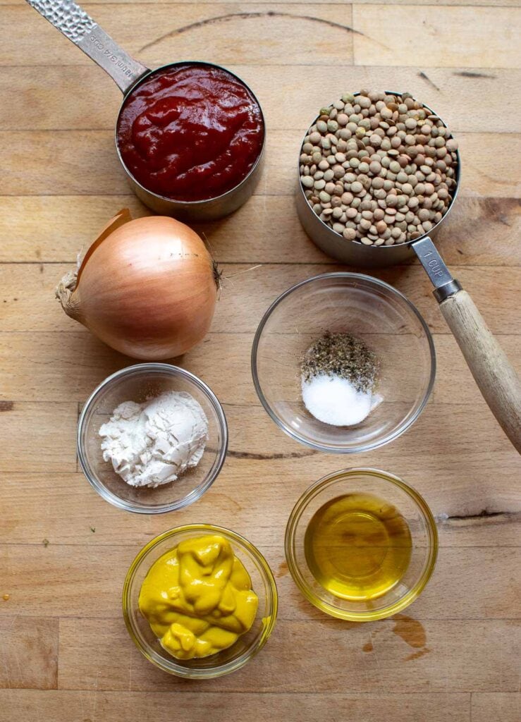 Ingredients to make vegan sloppy Joes including green lentils, onion, chili sauce, mustard and flour.