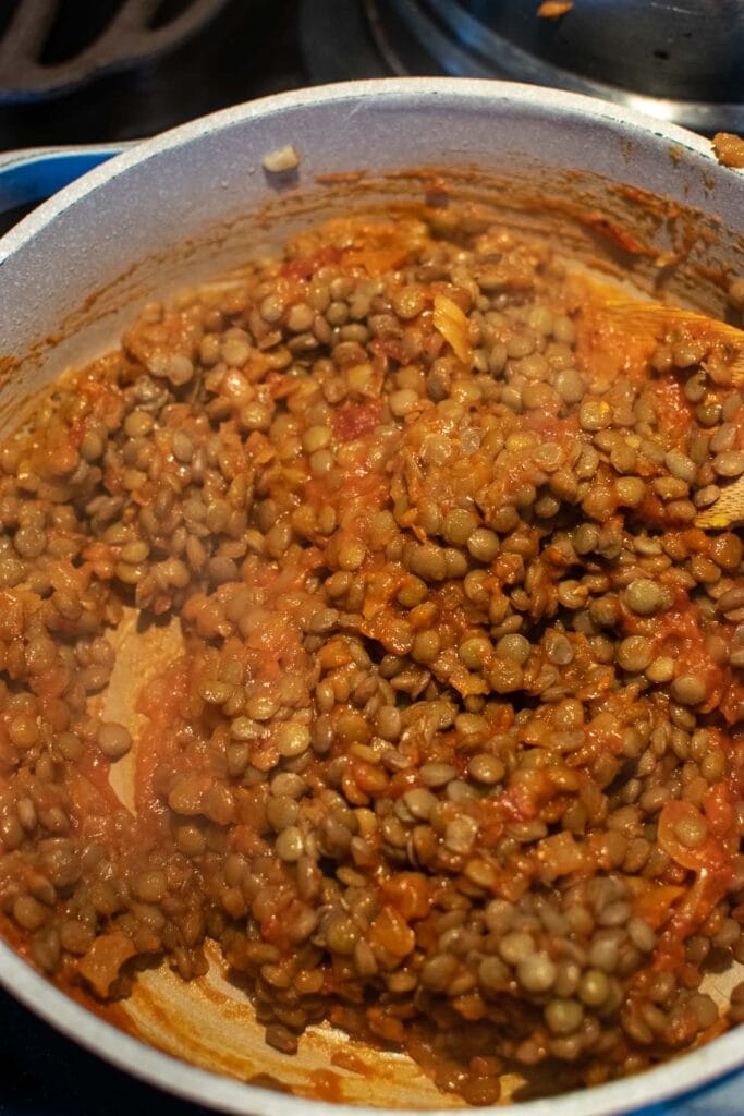 Cooked green lentils added to a pan with a chili sauce mixture to make sloppy Joes.