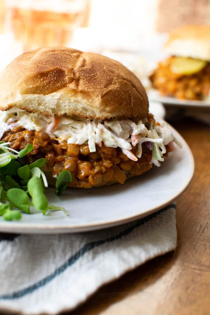 A meatless sloppy Joe made with green lentils and served topped with Cole slaw on a toasted bun.