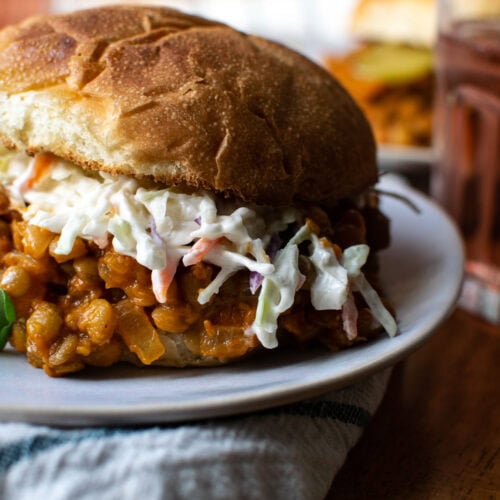 A sloppy Joe made with lentils and topped with Cole slaw on a toasted roll.