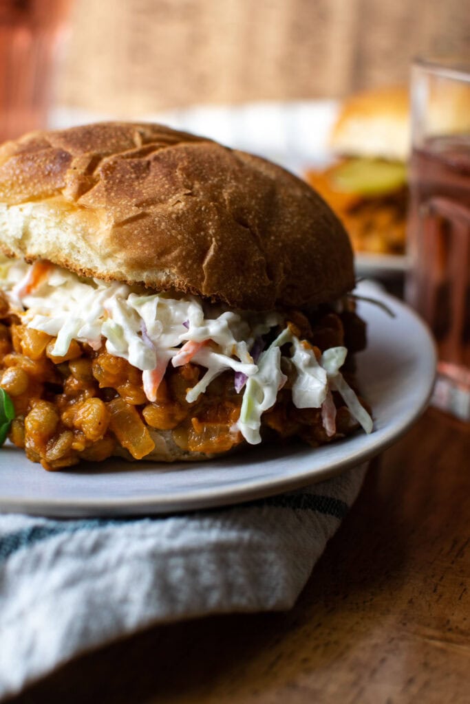 A sloppy Joe made with lentils and topped with Cole slaw on a toasted roll.