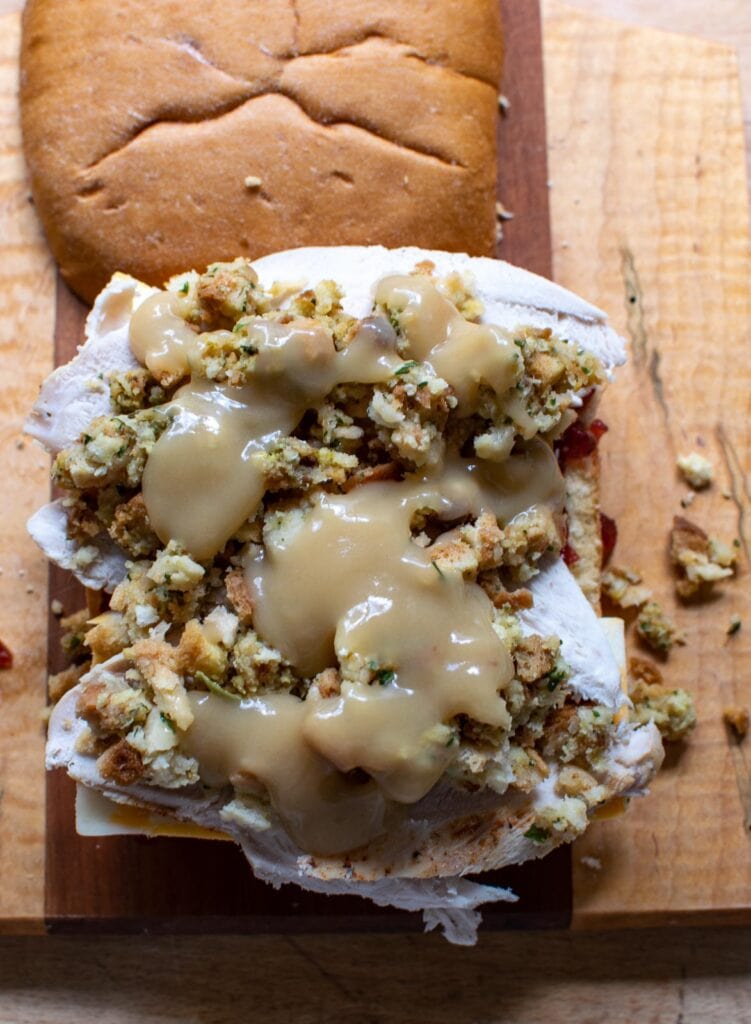 Stuffing and gravy layered on top of turkey slices to make a turkey sandwich.