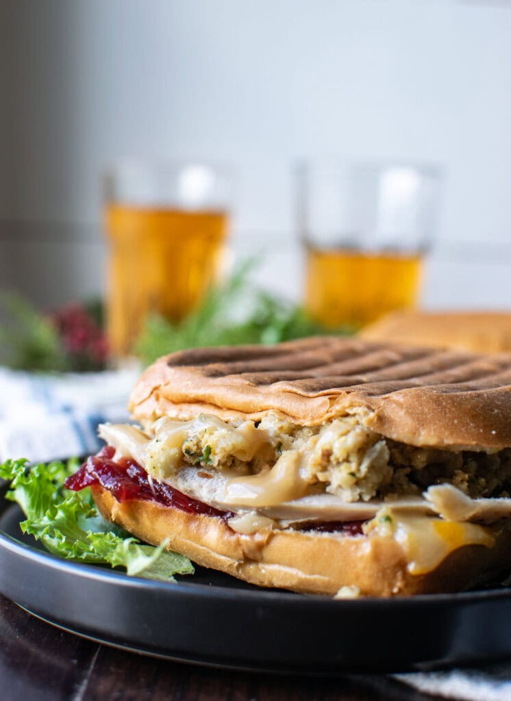 A sandwich made with leftover turkey, stuffing, cranberry sauce, gravy and cheddar cheese on a bun and grilled in a panini press.
