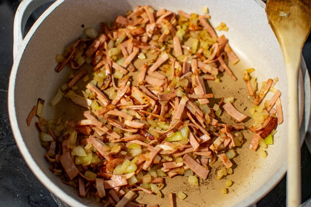 Chopped onions and sliced bacon after browning in a frying pan.