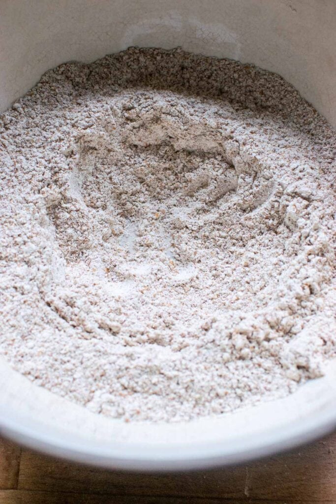 Dry ingredients for muffins with a well made in the centre ready for the wet ingredients to be added.