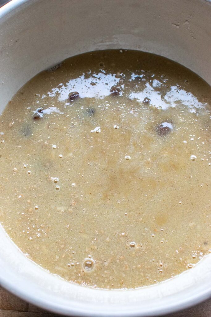Wet ingredients for muffins poured in a well made in the centre of the dry ingredients in a large mixing bowl.