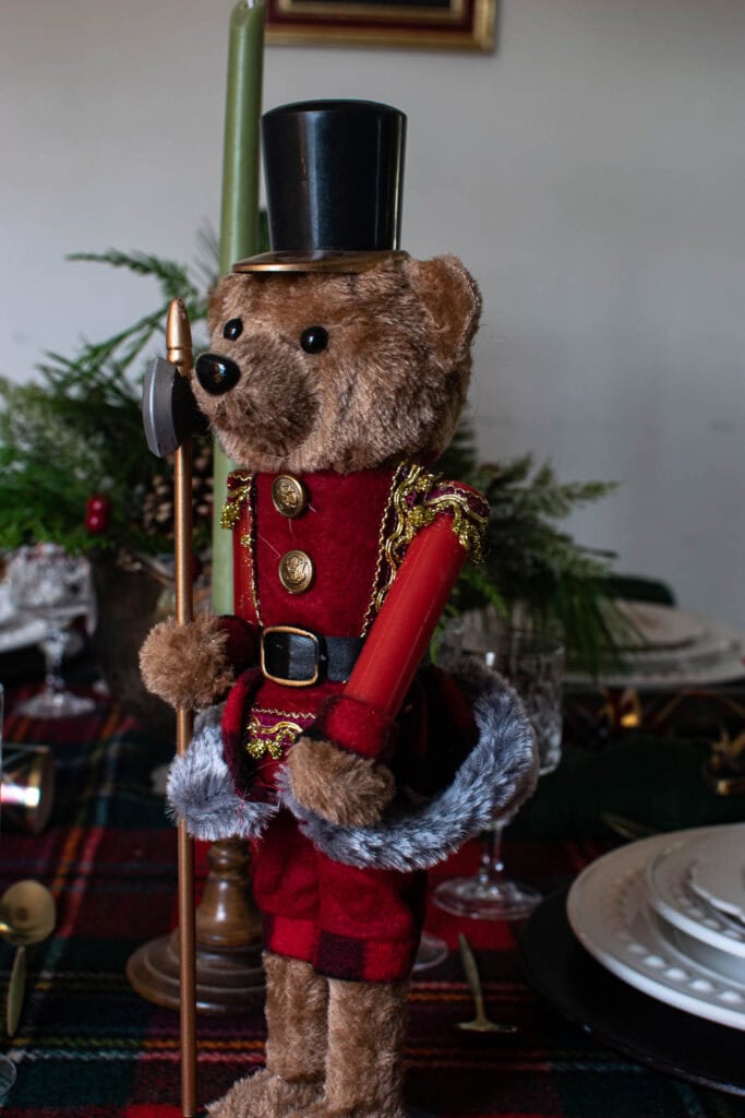 A teddy bear nutcracker on a Ralph Lauren inspired Christmas table.
