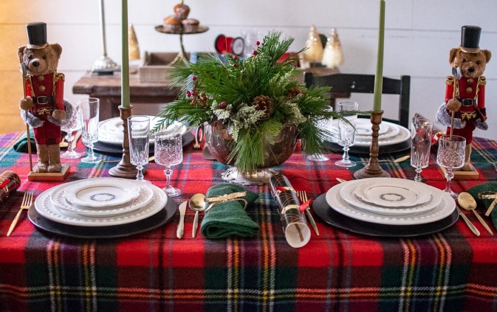 A Ralph Lauren Inspired Christmas tablescape with a classic tartan tablecloth, teddy bear nutcrackers and white dinnerware.