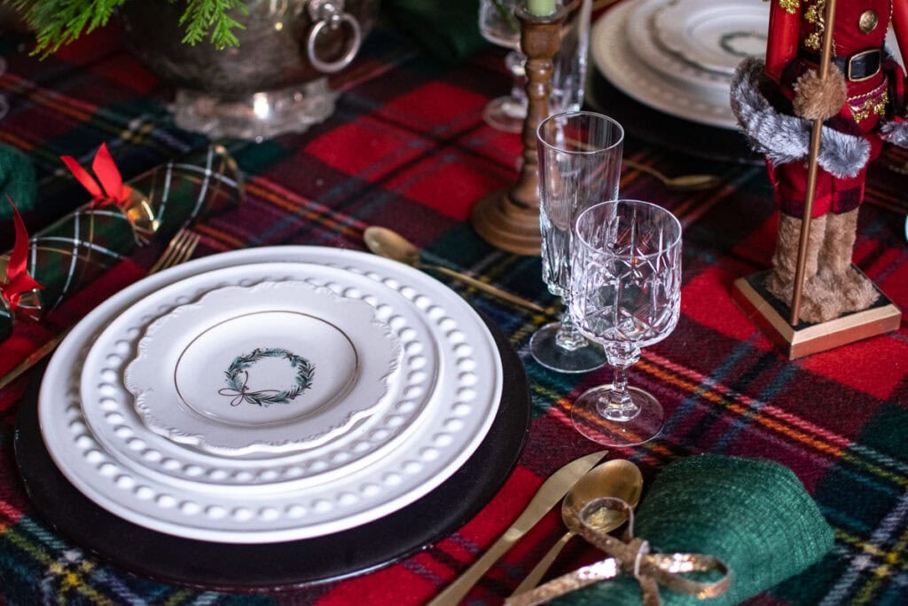 A traditional Christmas dinner table with a tartan table coth and festive dinner plates and accessories.