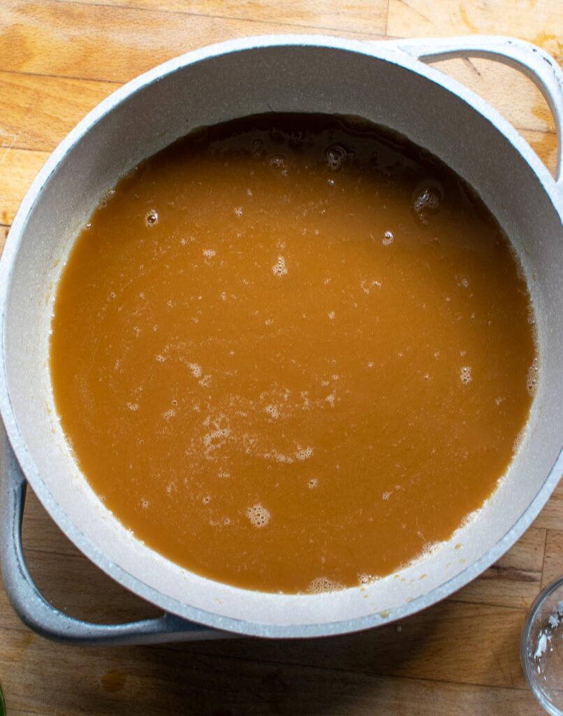 Sweet and sour sauce made in a deep frying pan before thickening.
