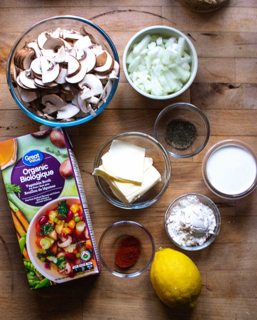 Ingredients to make homemade cream of mushroom soup including vegetable broth, onions, mushrooms and butter.