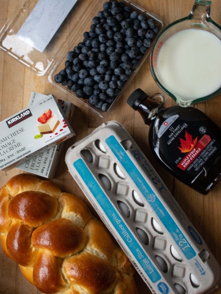 Ingreidents to make Blueberry French Toast Casserole including brioche bread, eggs, maple syrup, cream cheese, milk and blueberries