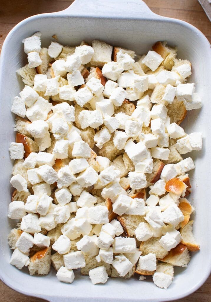 Small cubes of cream cheese sprinkled over top of cubed bread.