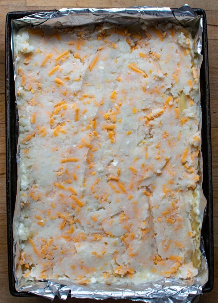 Potato and cheese mixture spread to cover the layer of lasagna noodles.