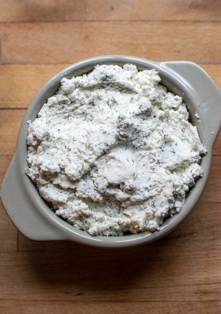 Ricotta dill mixture in a small ceramic baking dish.