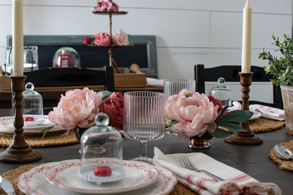 Faux pink roses in little tarnished silver ice cream dishes as a centrepiece on a Valentines Day Table