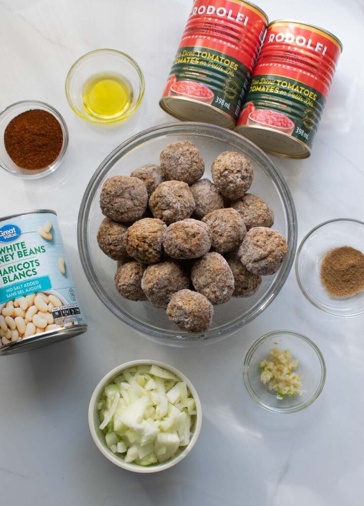 Ingredients for meatball chili casserole including meatballs, diced canned tomatoes, kidney beans and spices.
