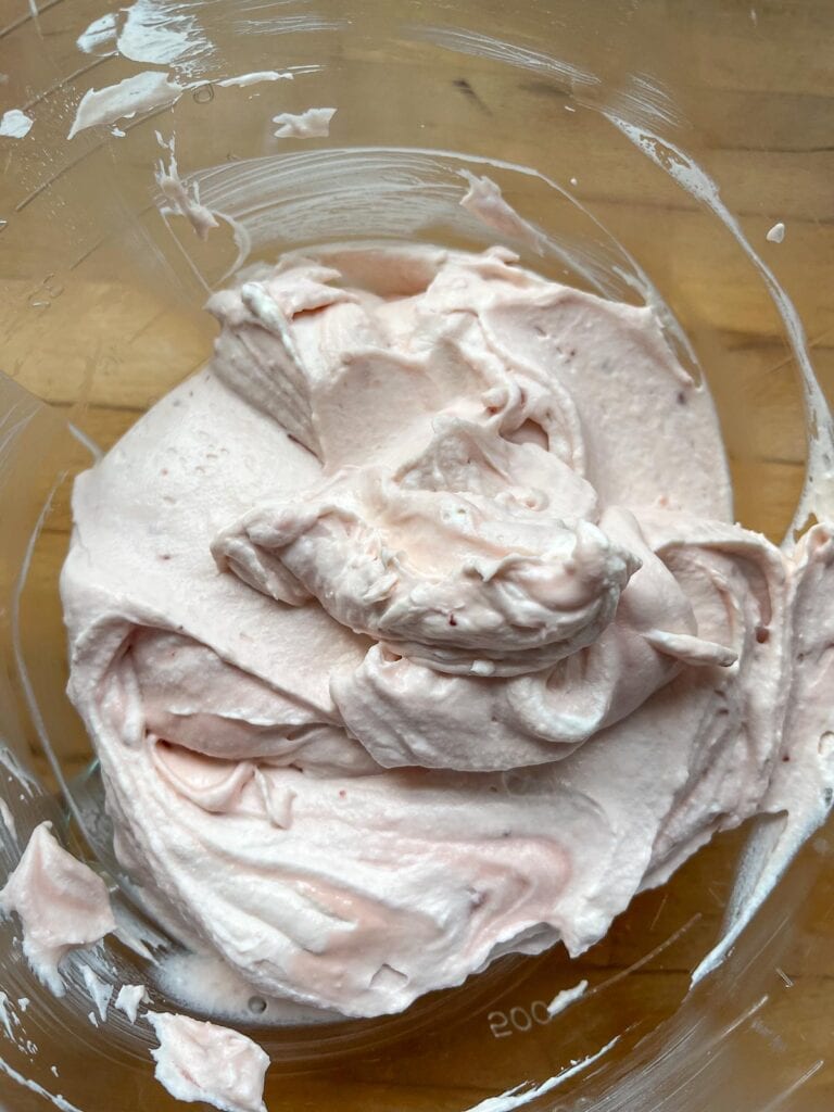 Freshly made strawberry cream cheese mousse in a glass mixing bowl.
