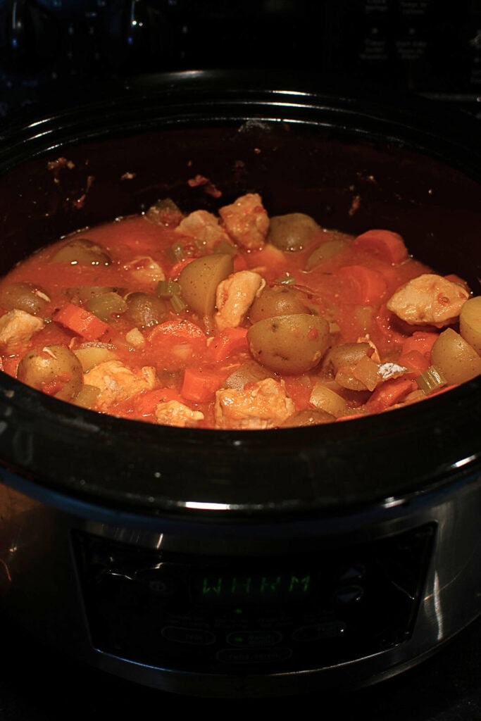 A crock pot filled with chicken stew that has been cooking on low for 7 hours.