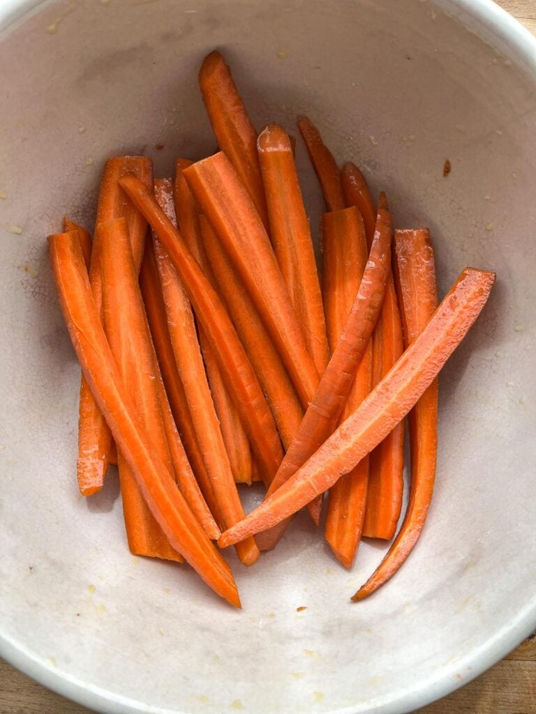 Vertically sliced carrots in a large mixing bowl