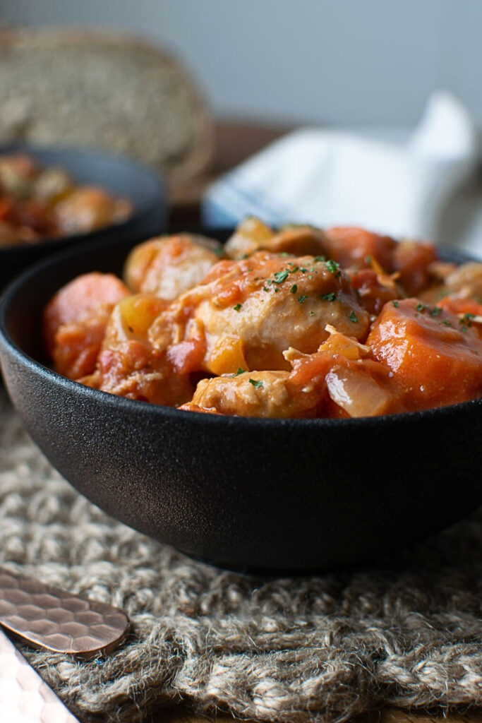 A black bowl filled with slow cooker chicken stew.