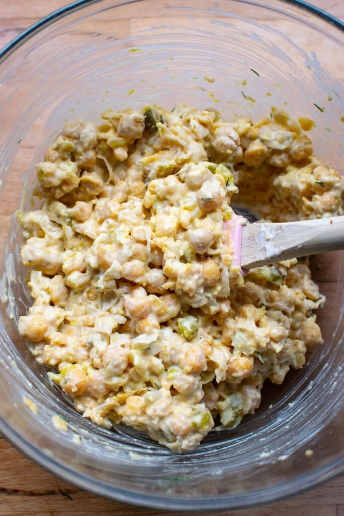 Freshly made dill chickpea salad in a glass mixing bowl.