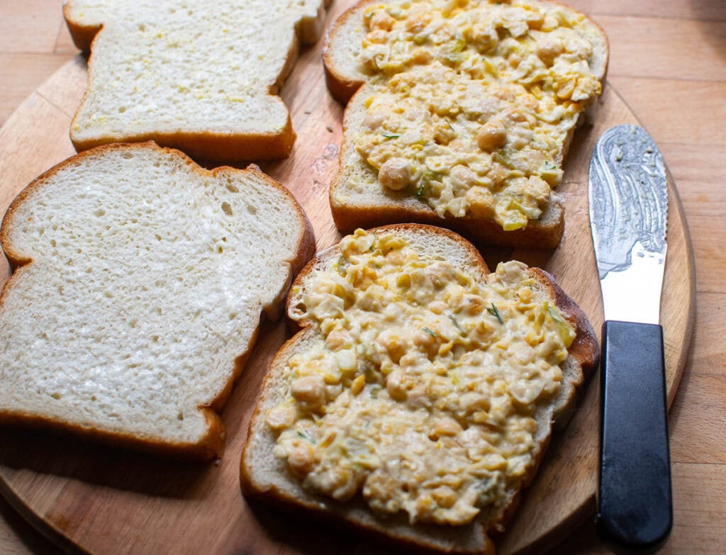 Fresh sandwich bread spread with chickpea salad.