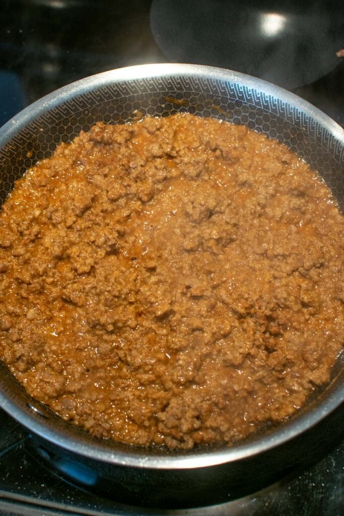 Taco seasoning mix and water added to browned ground beef and brought to a simmer on the stove top.