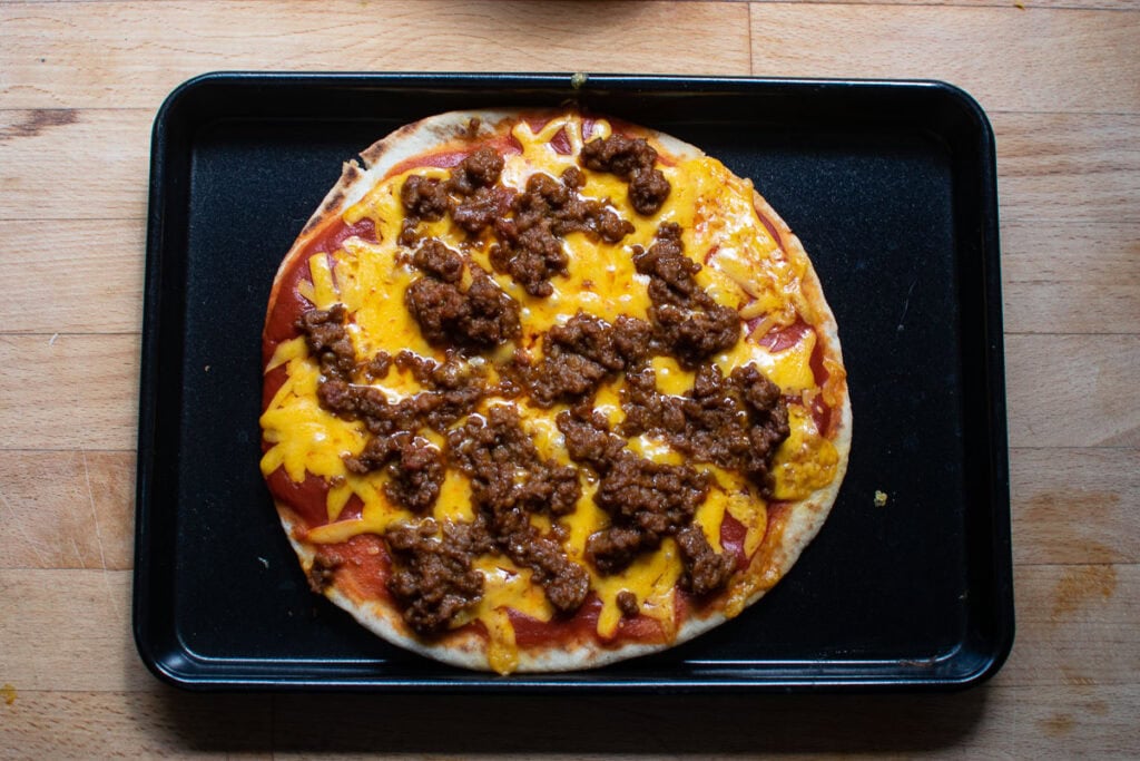 A taco pizza made on Naan bread fresh out of the oven.