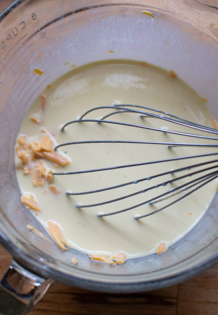 Cream, eggs, dijon mustard and shredded cheese whisked together in a large mixing bowl.