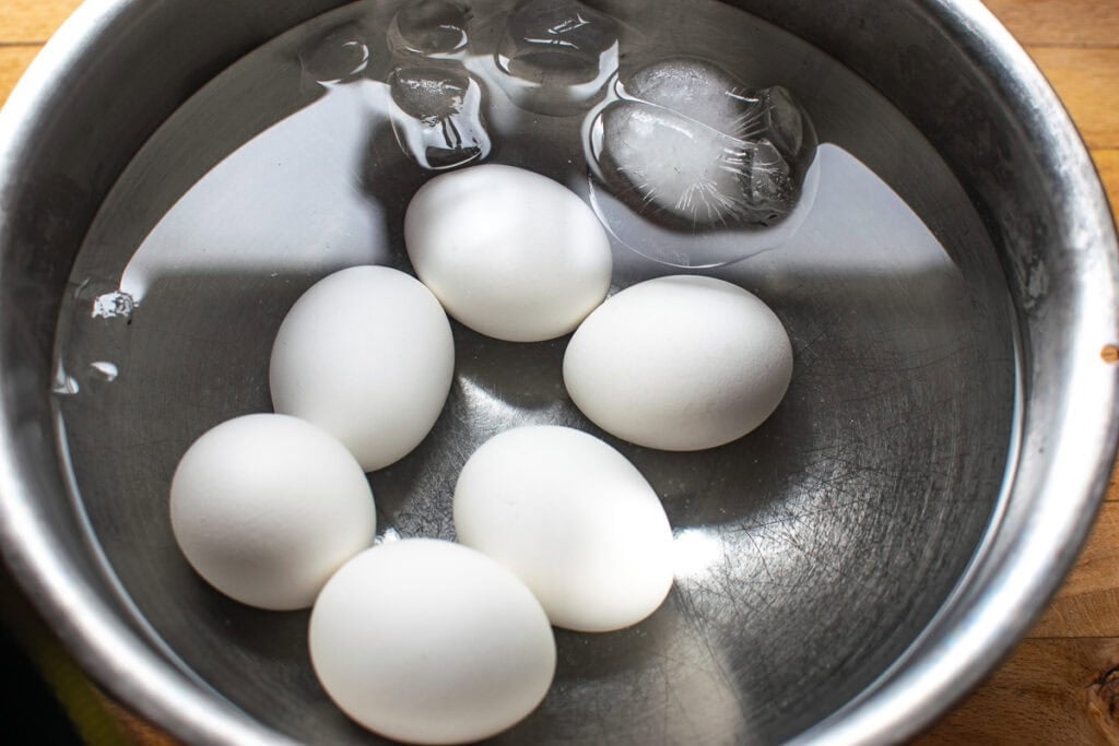 Six hard boiled eggs in an ice bath.