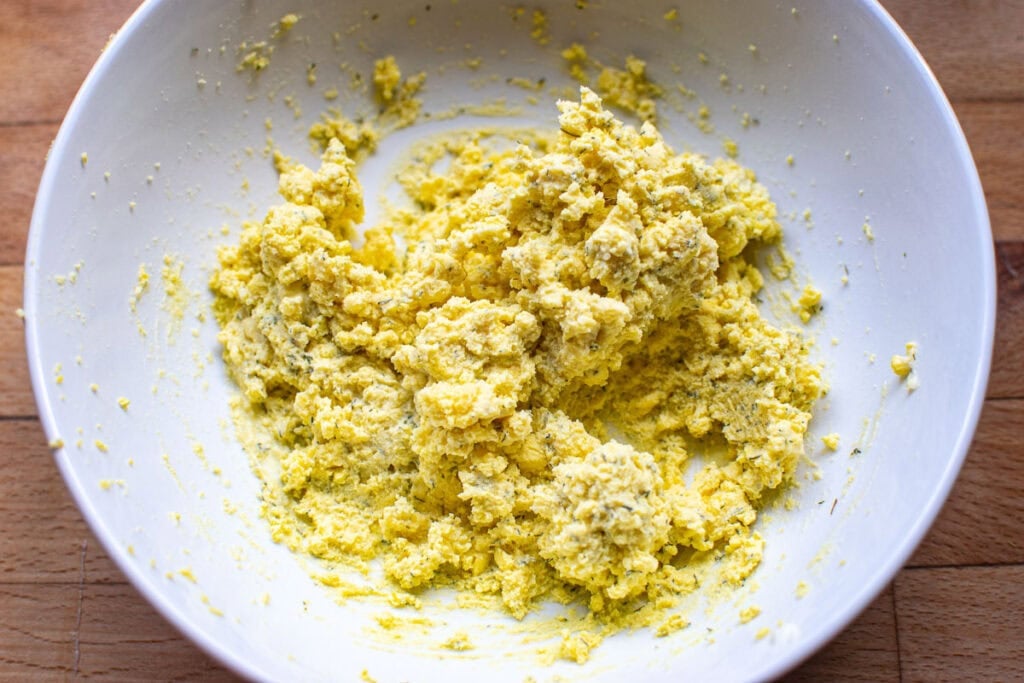 Dill deviled egg filling in a glass bowl.
