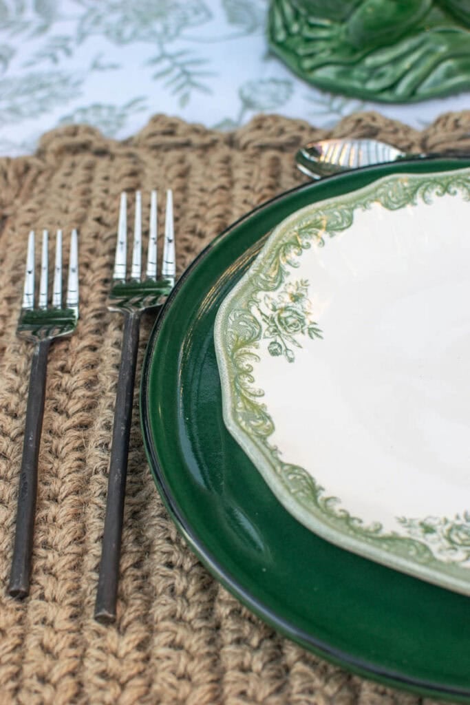 A close up of the green dinner plate, transfer ware salad plate and twig flatware set for a summer dinner.