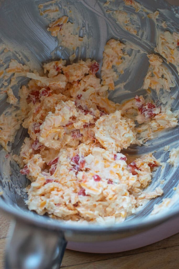 Freshly mixed pimento cheese spread in the bowl of electric stand mixer.