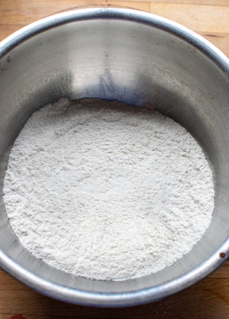 Dry ingredients to make Strawberry muffins in a mixing bowl including, flour, sugar and baking powder.