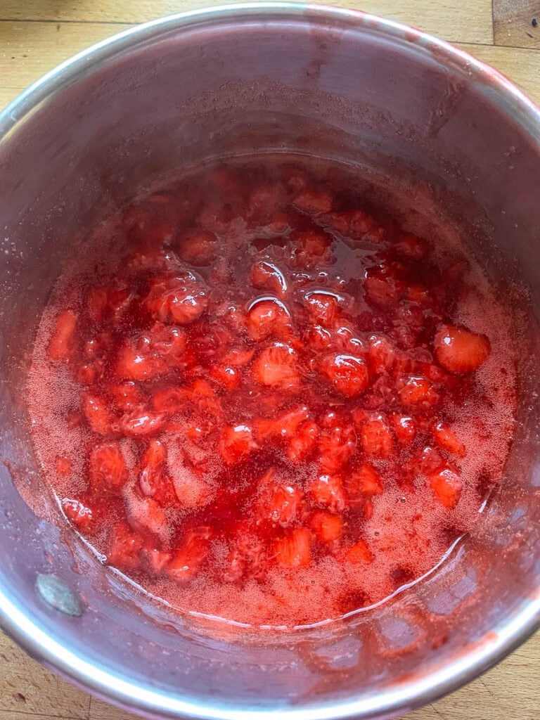 Freshly made strawberry sauce in a sauce pan.