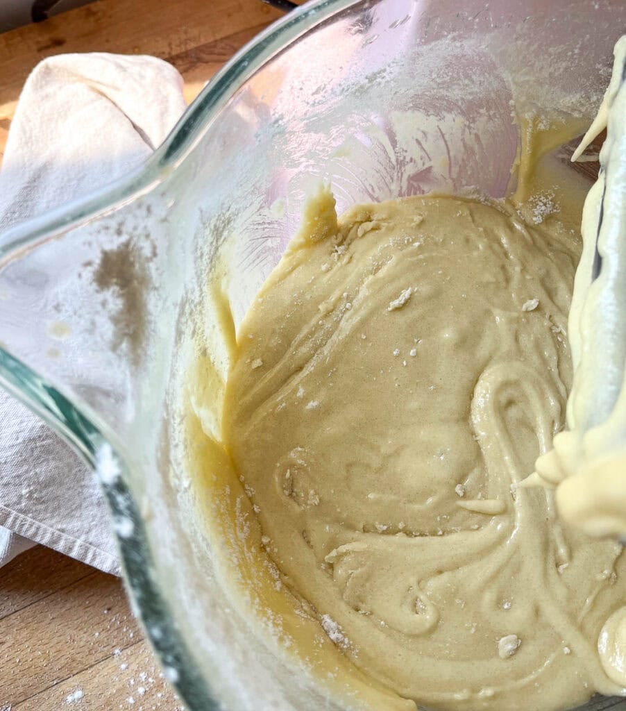 Sugar fully incorporated into beaten eggs in the bowl of an electric mixer.
