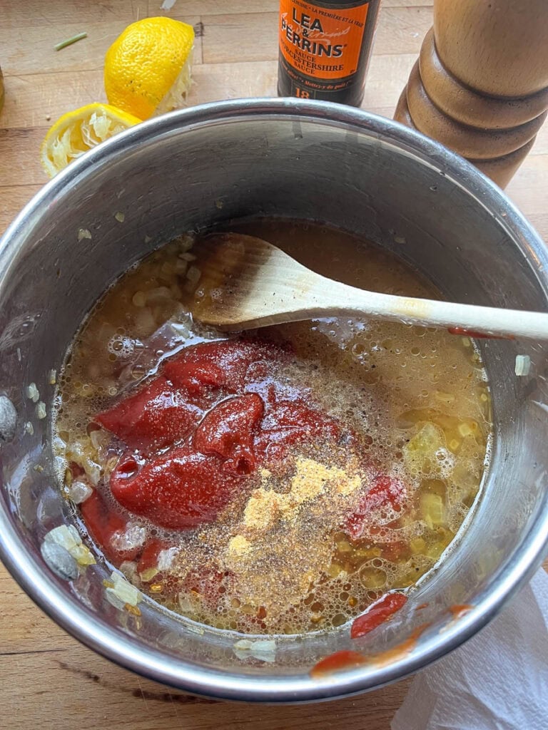 Ketchup, vinegar, sugar, lemon juice and spices added to the browned onions in a saucepan.