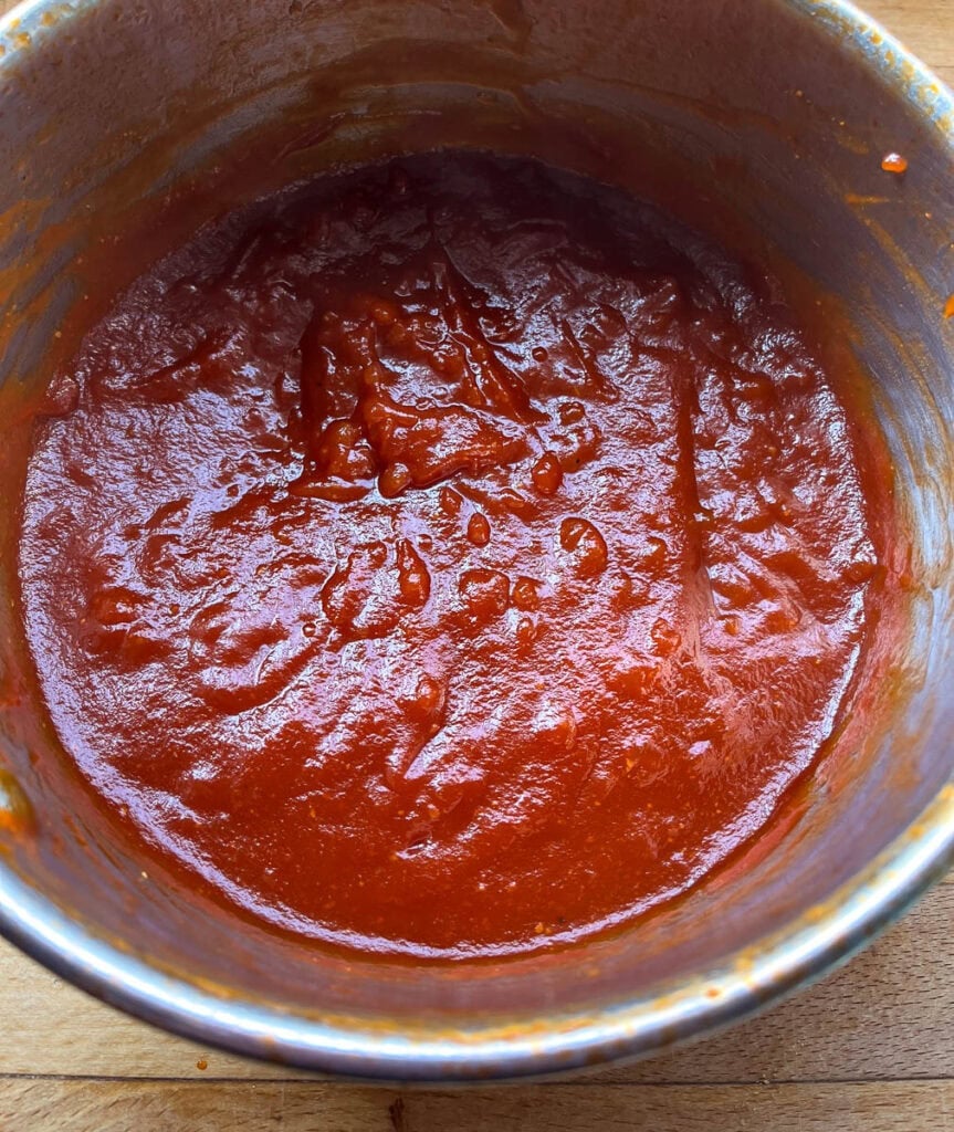 Homemade barbecue sauce that has been simmered for 30 minutes in a saucepan.