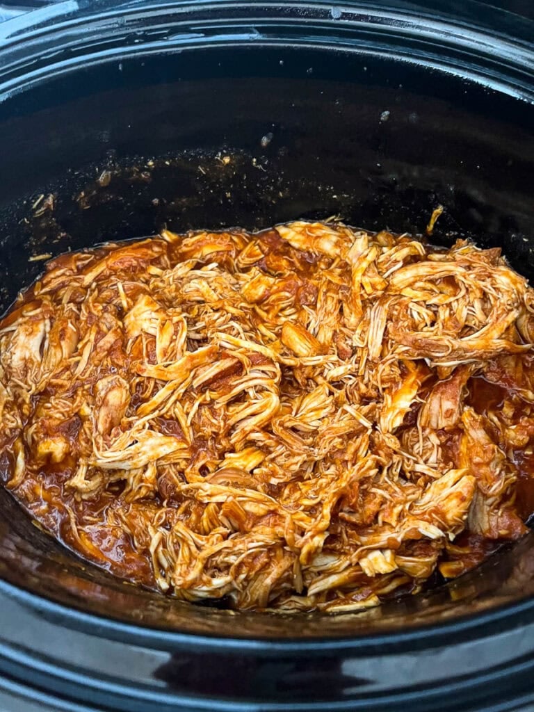 Shredded chicken in barbecue sauce in a slow cooker.
