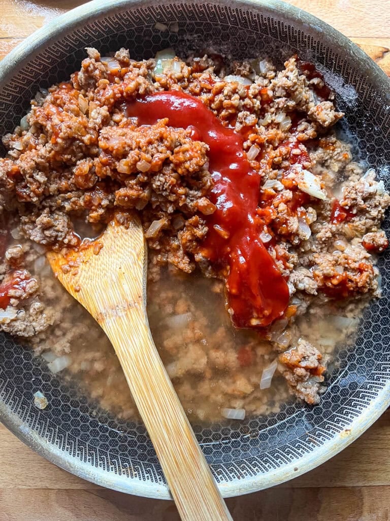 Flour, water, ketchup and Worcestershire sauce added to browned ground beef and onions in a frying pan.