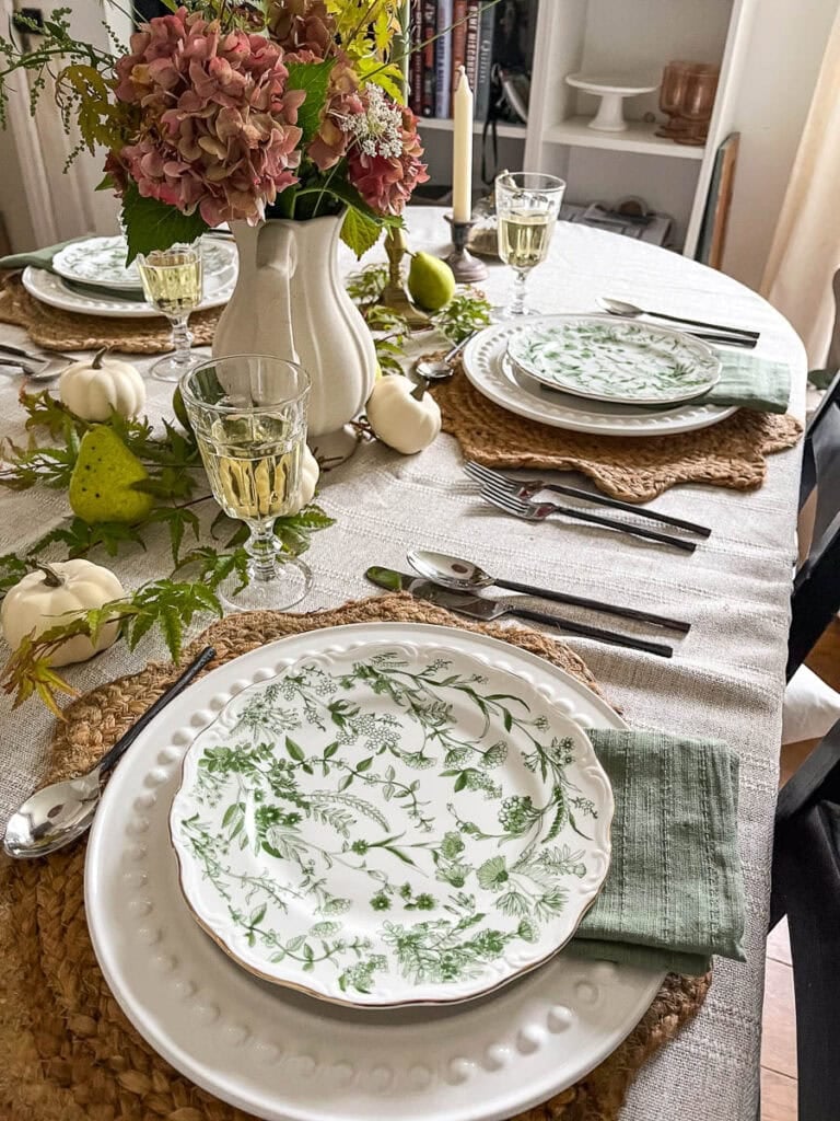 Two side by side place settings on a early fall tablescape inspired by Nancy Meyers movie sets.
