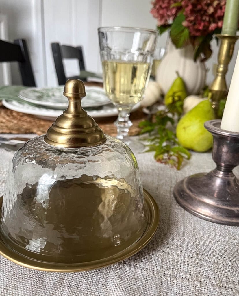 Gold trimmed glass butter dish on an table set for autumn.