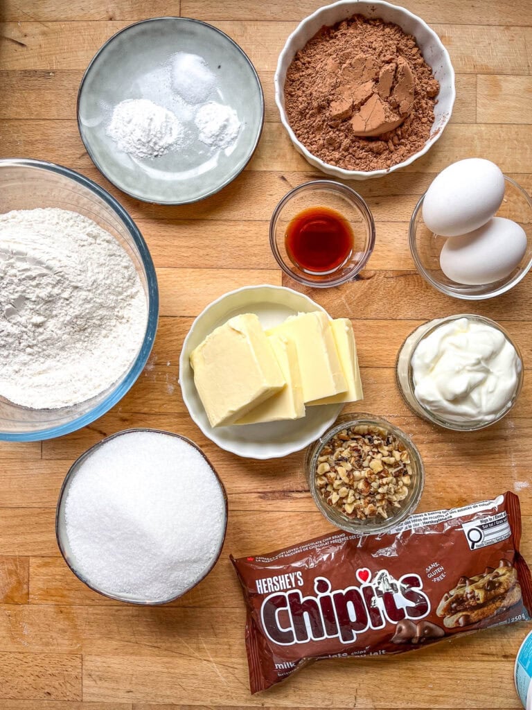 Ingredients to make brownie cookies including flour, butter, cocoa and chocolate chips.